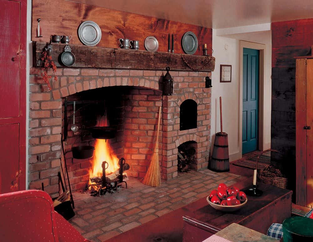 A Red Room With A Brick Fireplace And Red Chairs