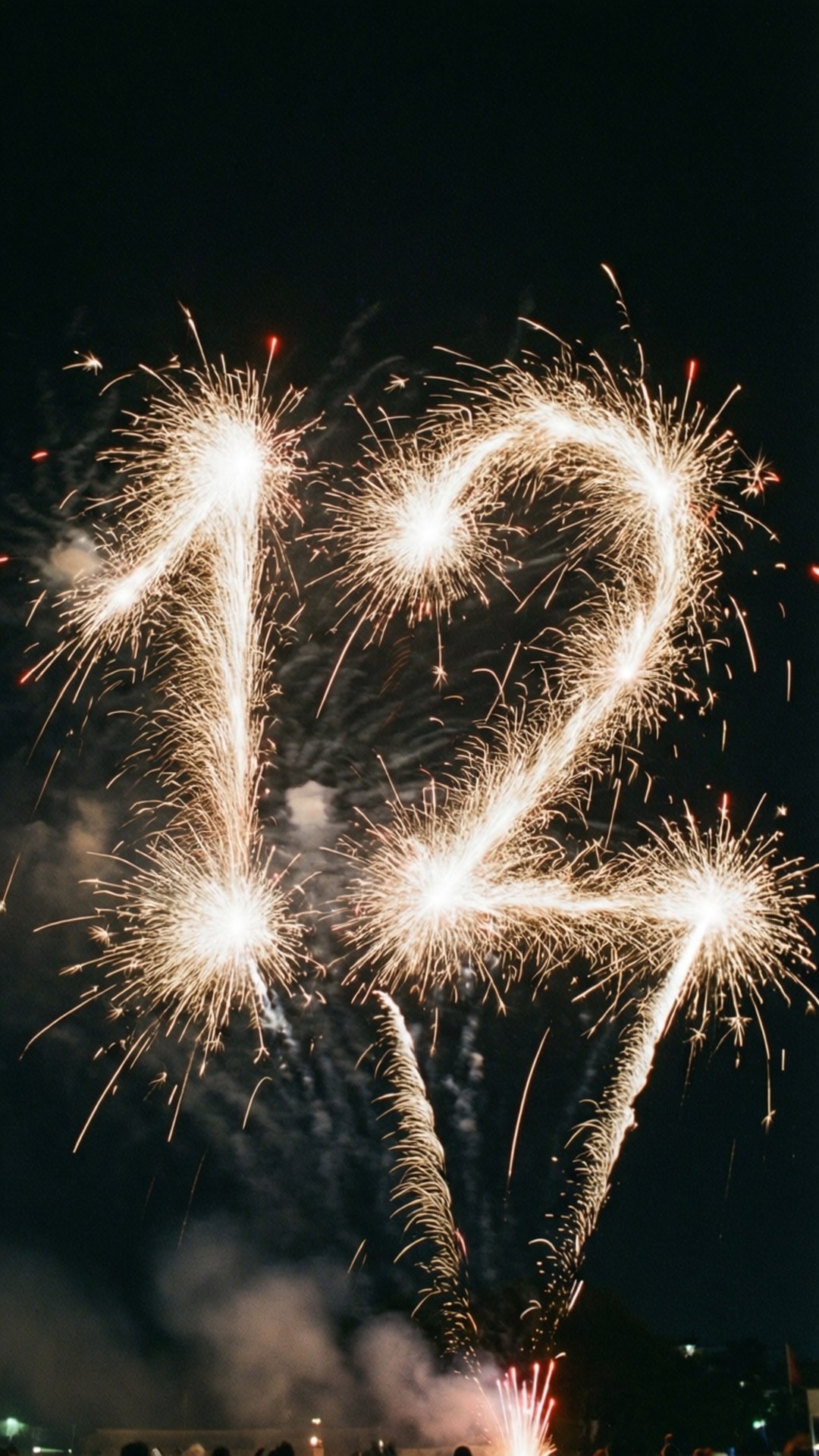 Die Zahl 12, geformt durch Feuerwerk am Nachthimmel.