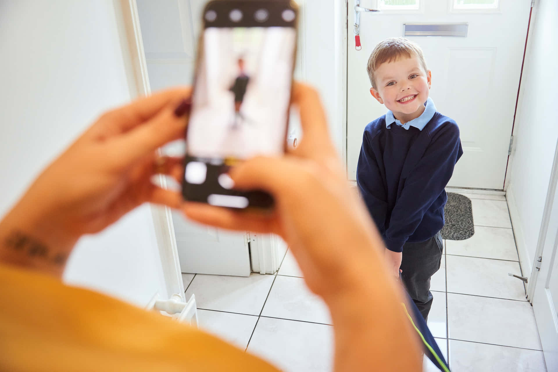 A Woman Taking A Picture Of A Boy In A Doorway