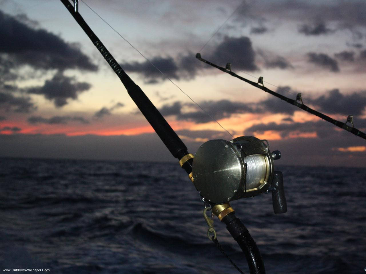 Enjoying a Quiet Moment of Fishing at Sunset Wallpaper