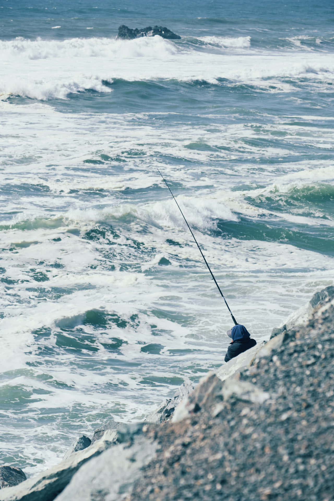 En mand fisker ud fra kysten Wallpaper