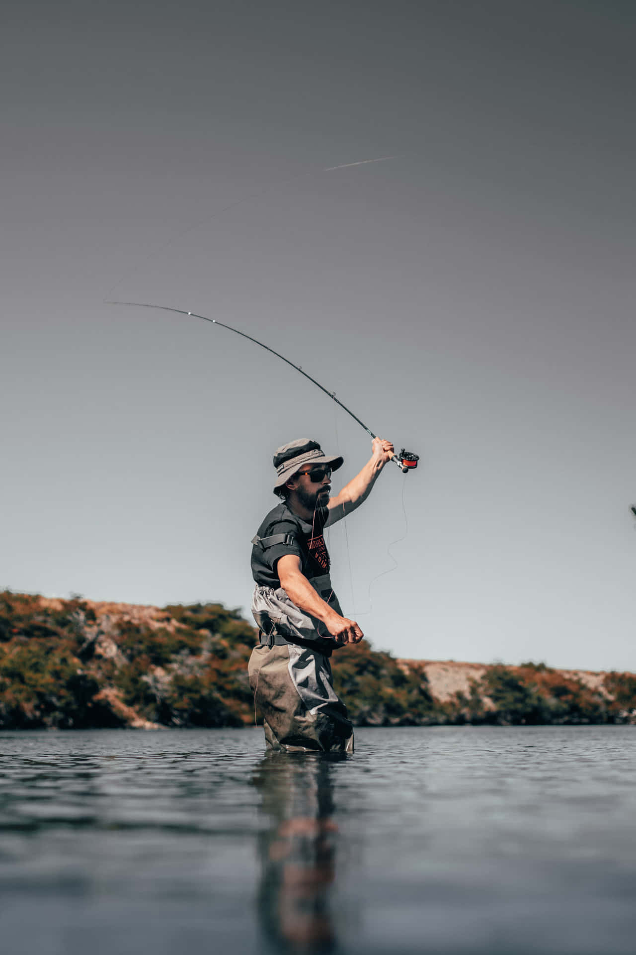 En mand fisker med flyvefiskeri i vandet. Wallpaper