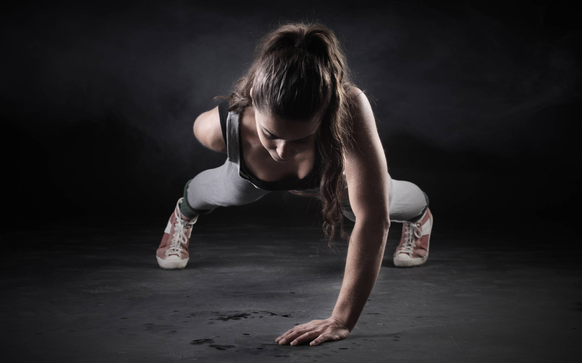 Fit Woman Performing One Handed Push-ups Wallpaper