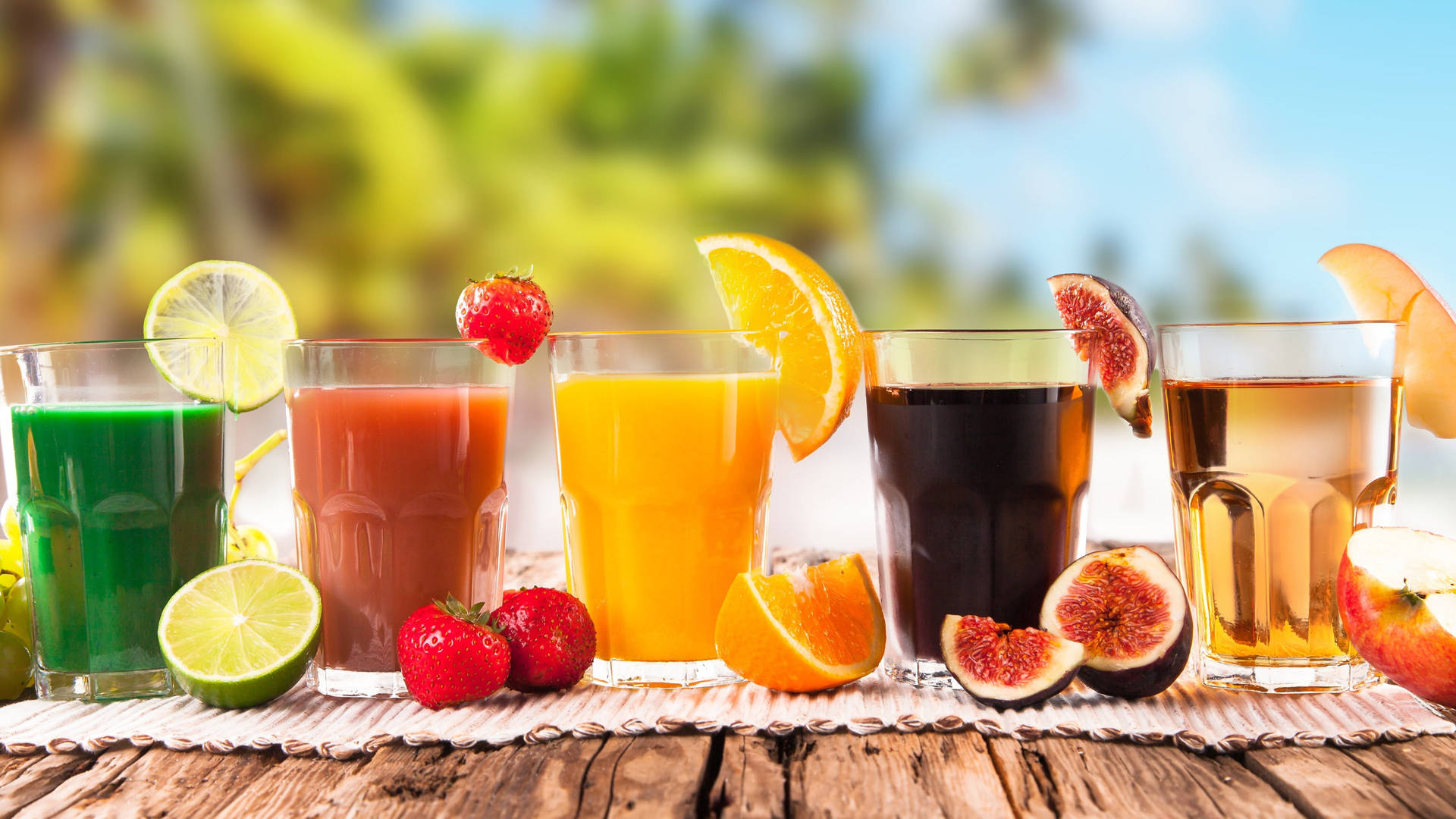 Fem tropiske drinks linet op på en bænk Wallpaper