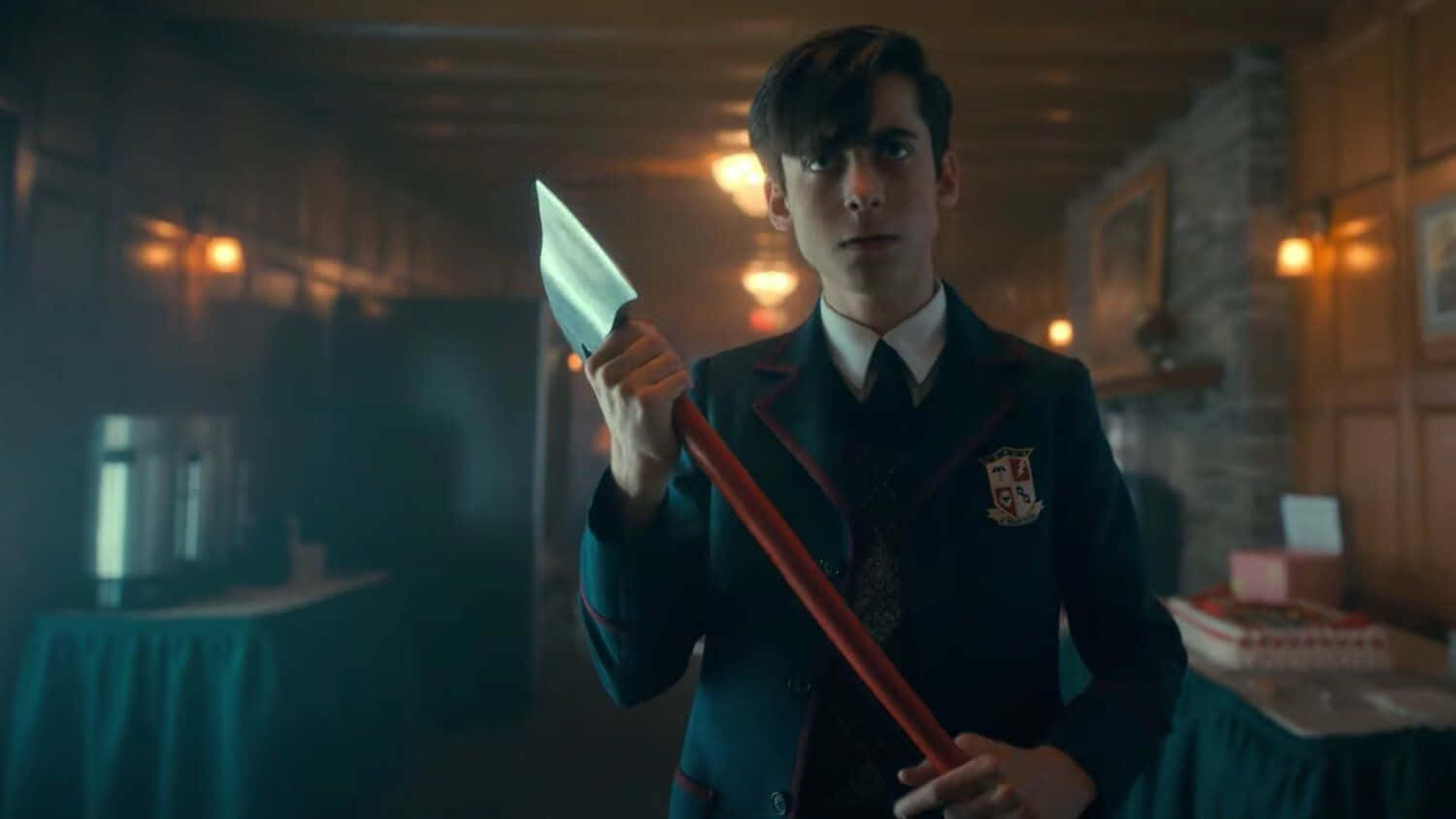 En ung mand i skoleuniform, der holder et stort kniv. Wallpaper