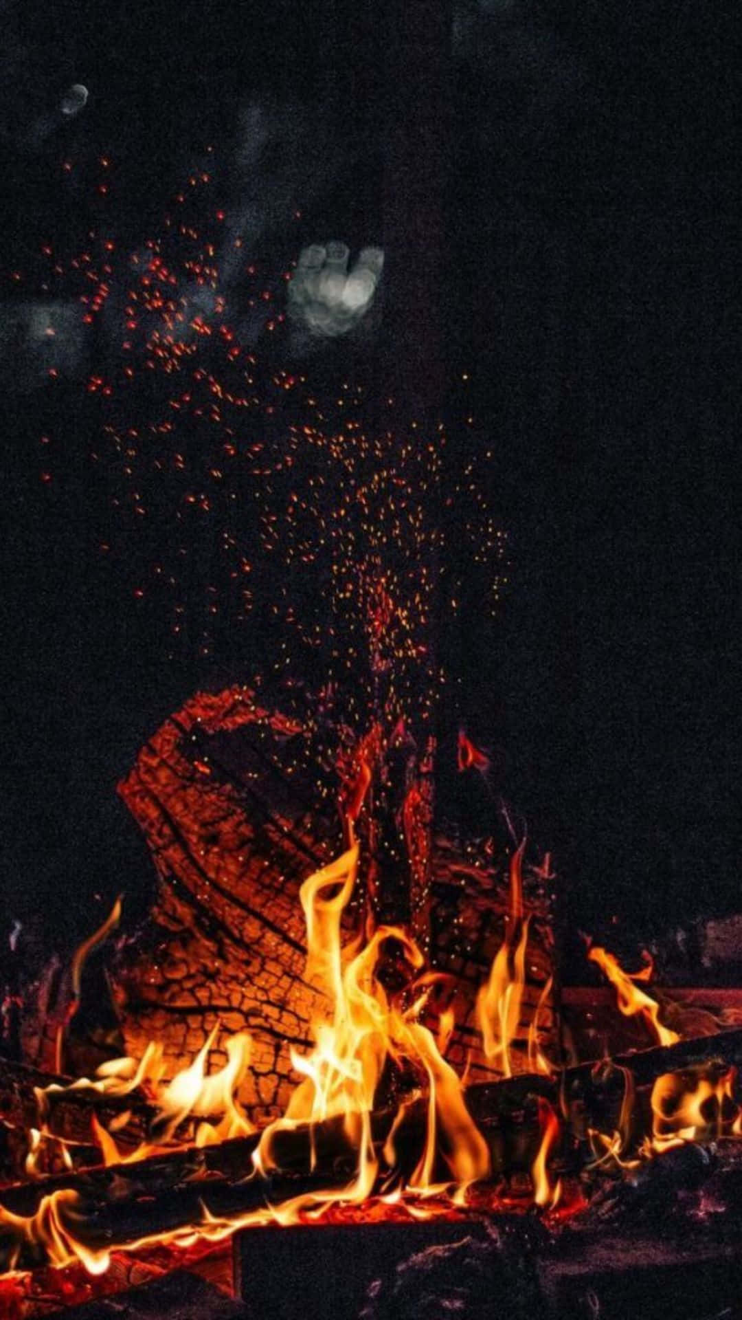 Tag et øjeblik og varm dig selv i flammerne fra en rolig lejrbål. Wallpaper