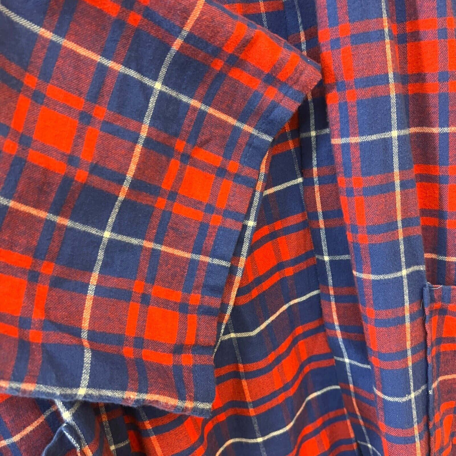 a red and blue plaid shirt hanging on a hanger