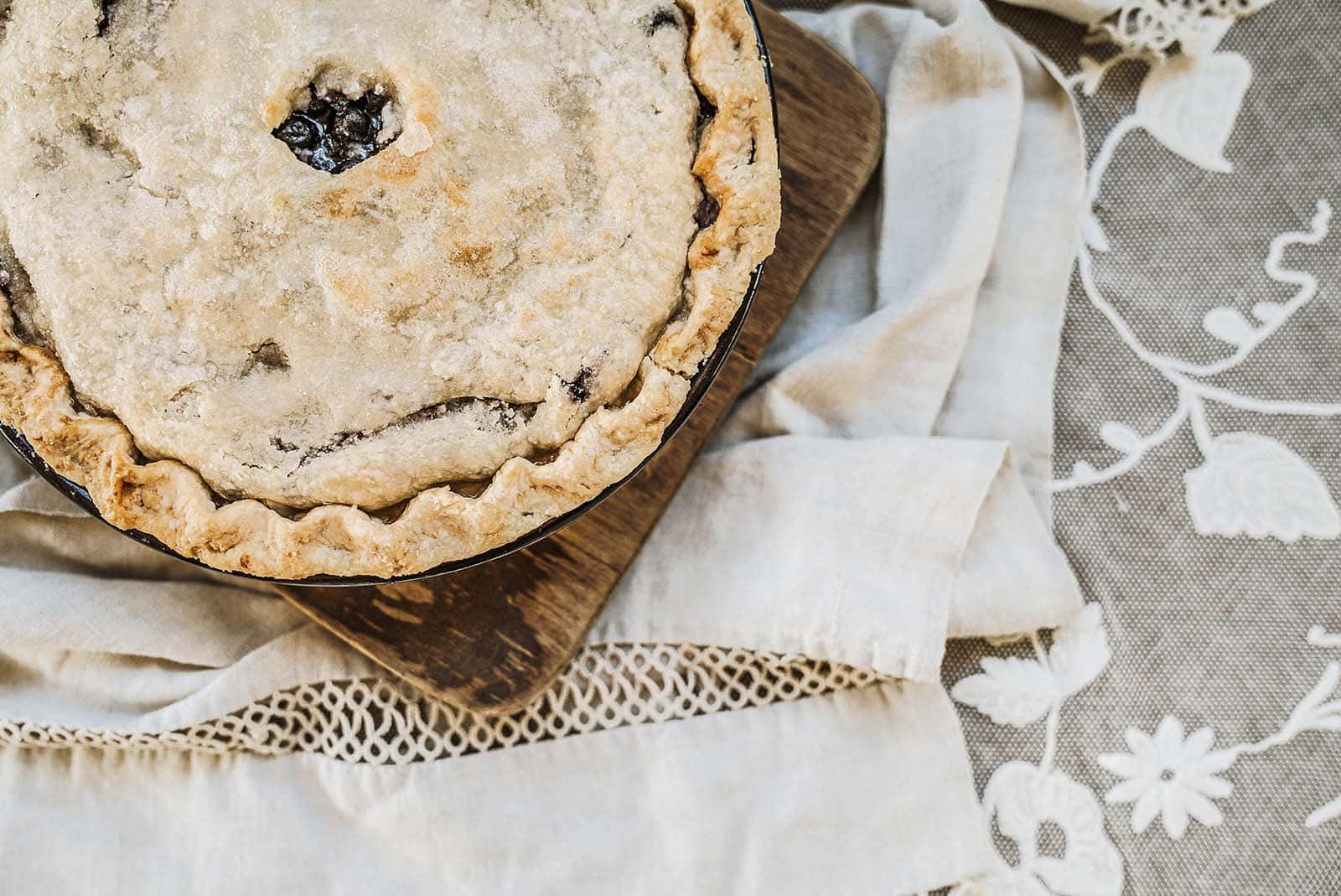A Pie On A Wooden Board With A Doily
