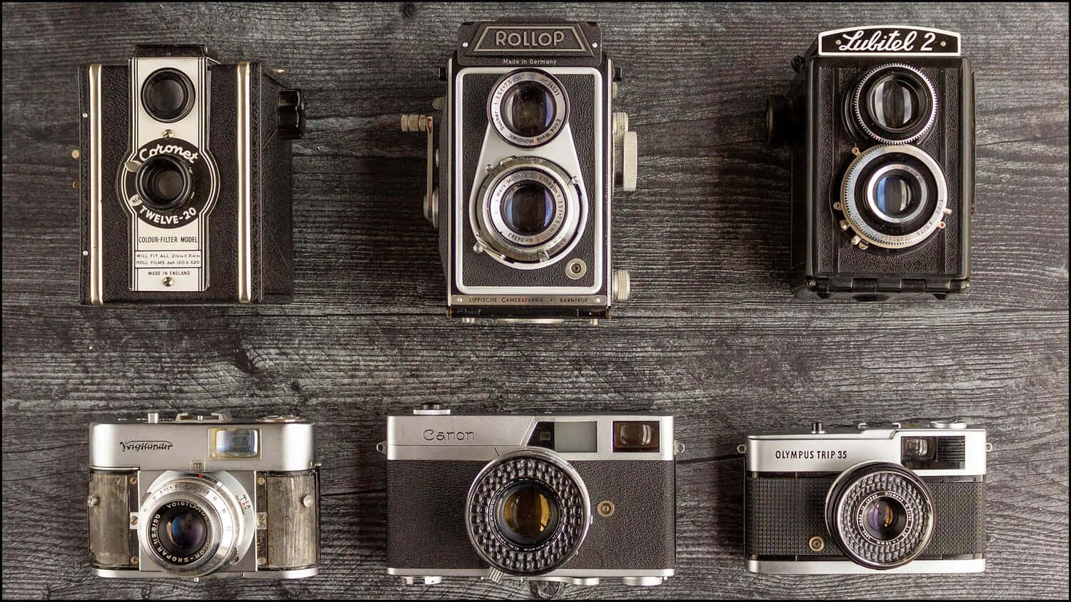A Group Of Vintage Cameras On A Wooden Surface