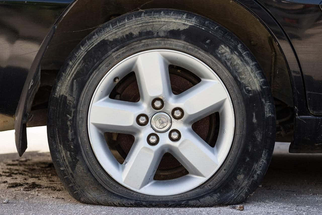 A Car Tire With A Flat Tire