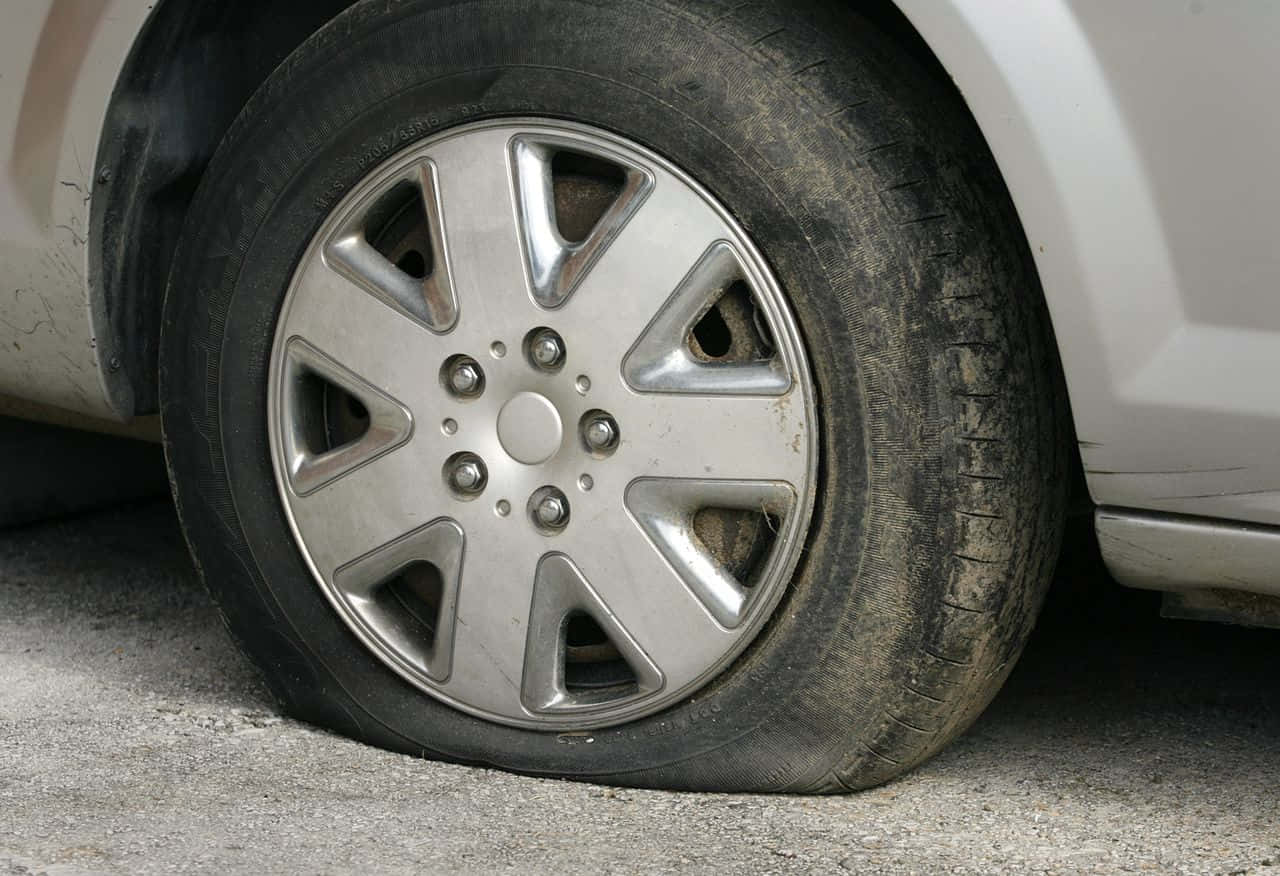En dæk på en bil sidder på jorden.
