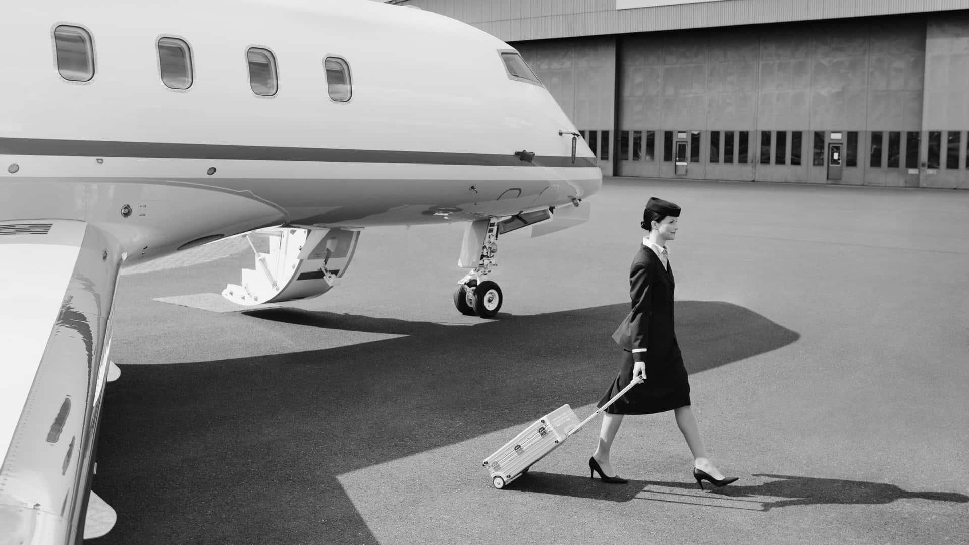 A stylish flight attendant wearing a uniform walking down the aisle.
