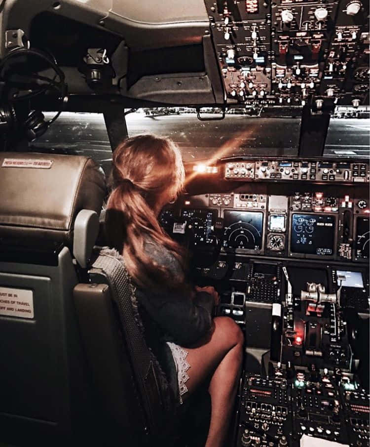 A Girl Sitting In The Cockpit Of An Airplane