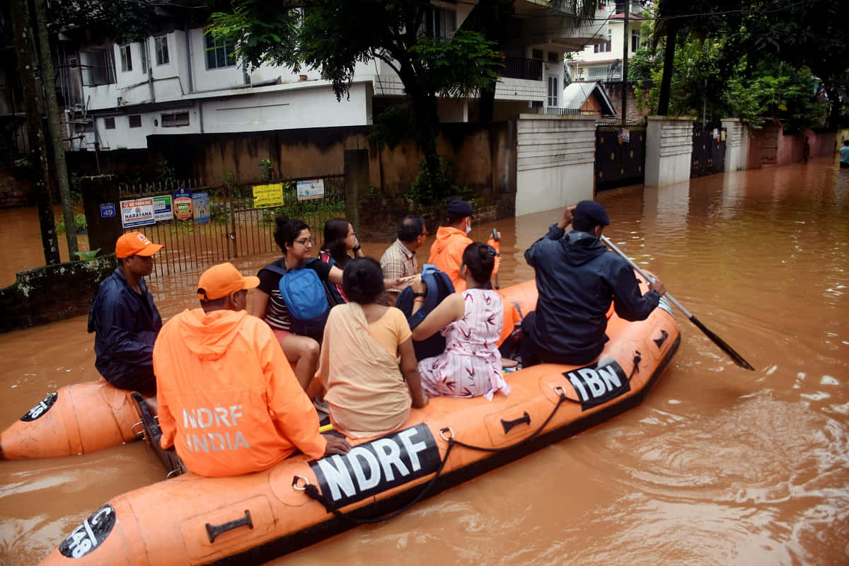People Riding In An Orange Raft In A Flooded Street