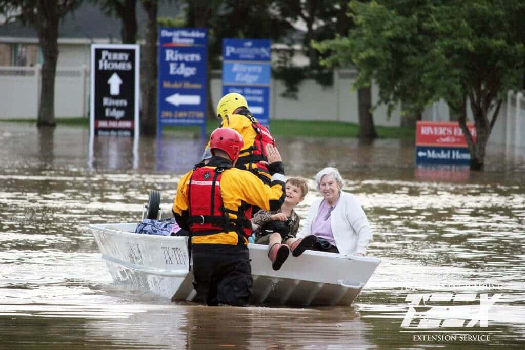 A Man And Woman Are In A Boat In A Flooded Street