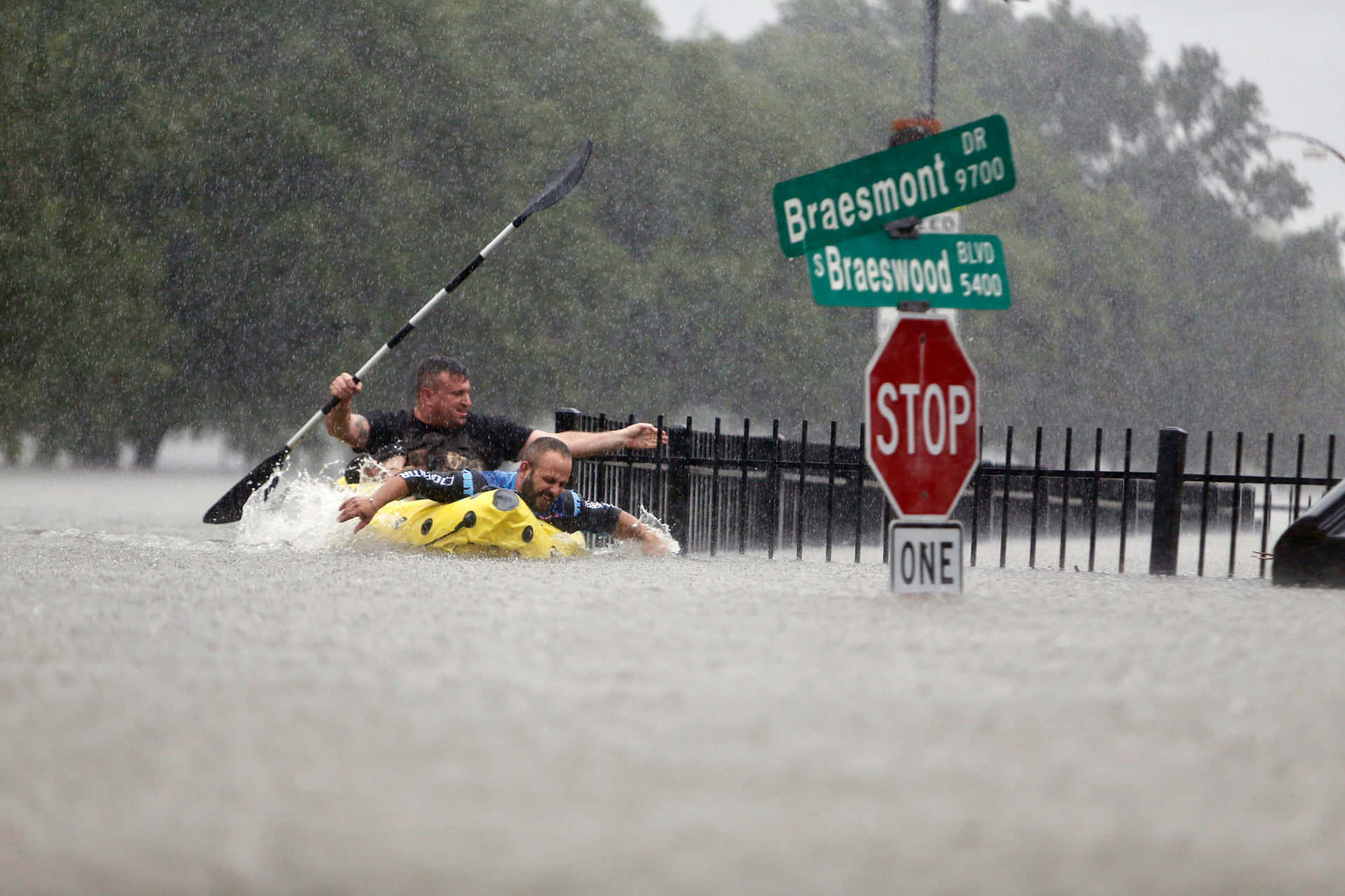 Two People In A Kayak In A Flooded Street