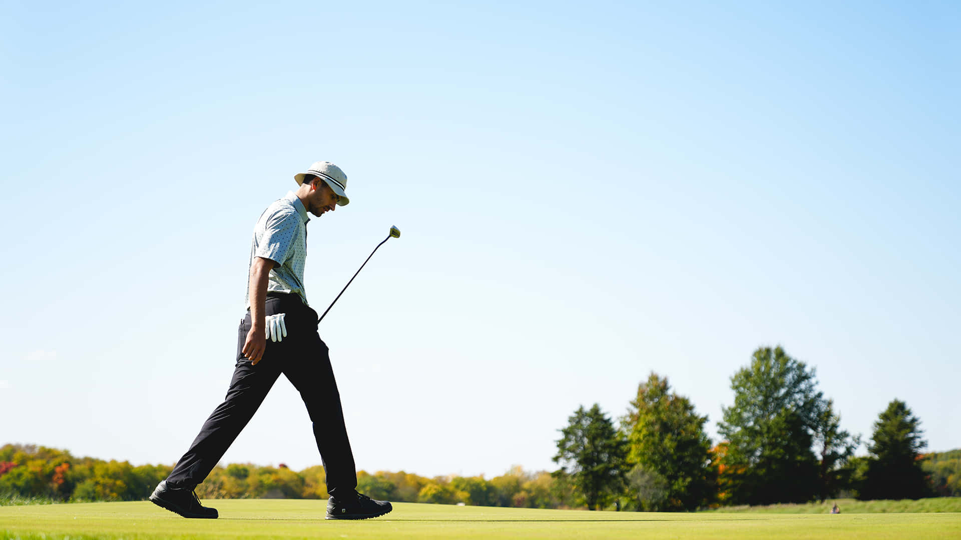 A Man Walking Across A Golf Course Wallpaper