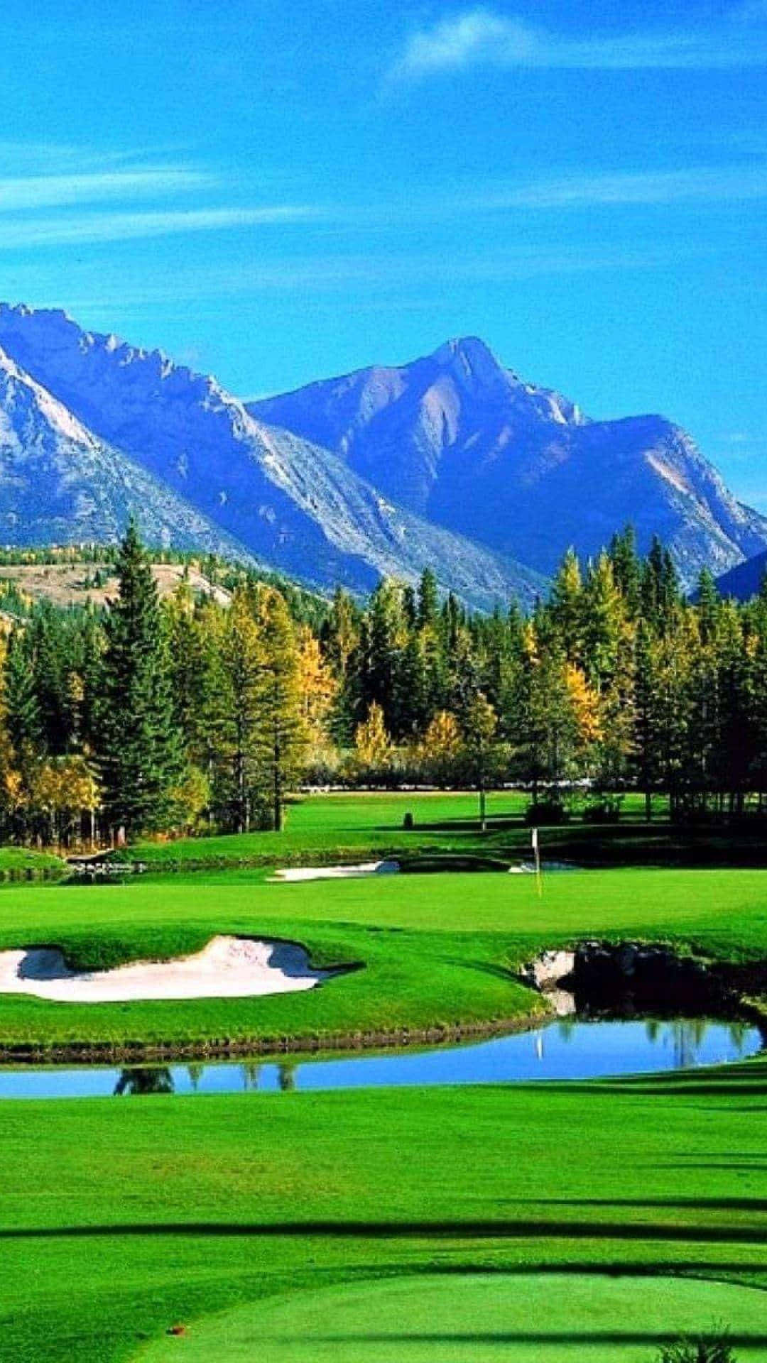 A Golf Course With Mountains In The Background Wallpaper