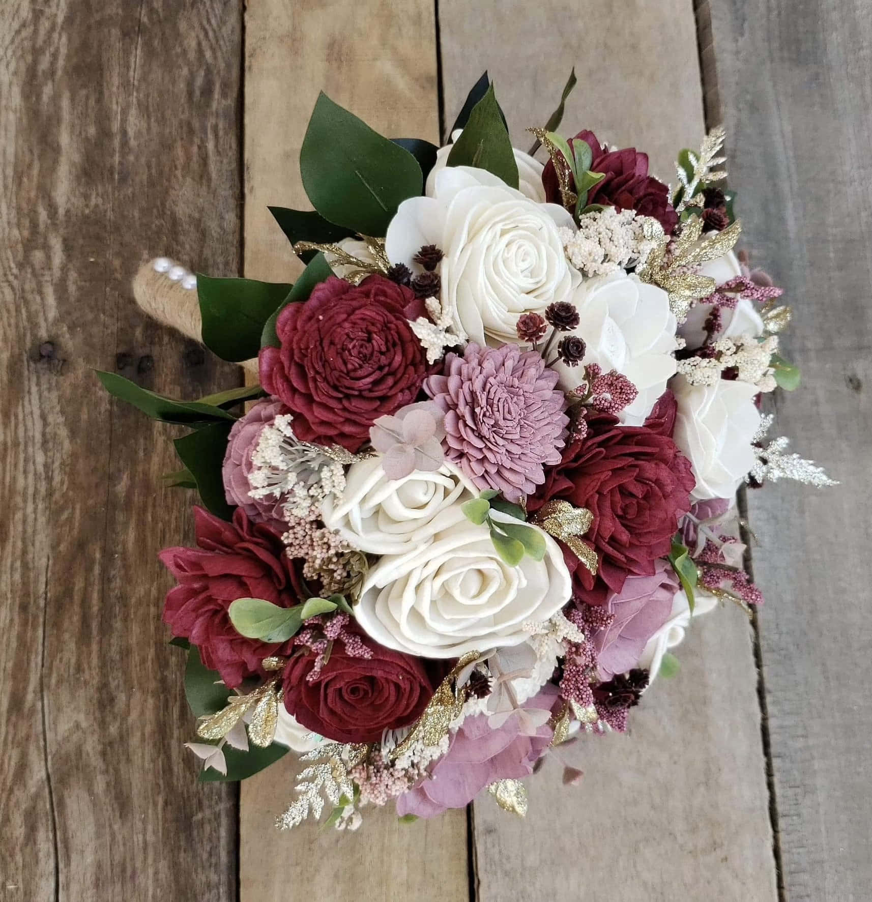 A Bouquet Of Burgundy And White Flowers On A Wooden Table