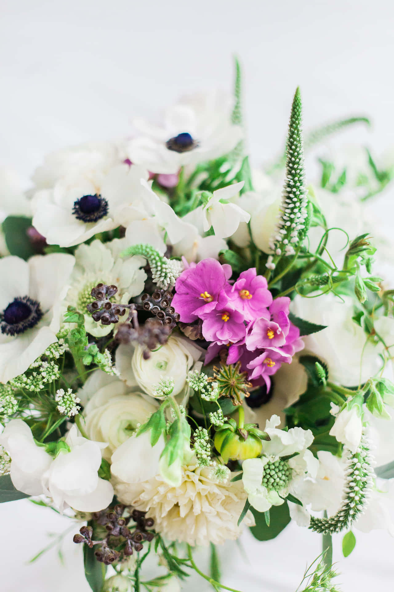 A White And Purple Bouquet With Greenery