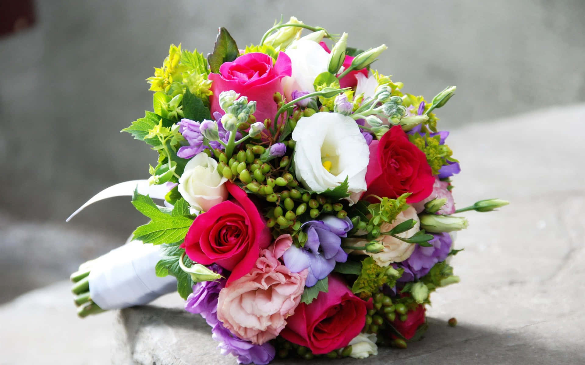 A Bouquet Of Flowers Sitting On A Stone Wall