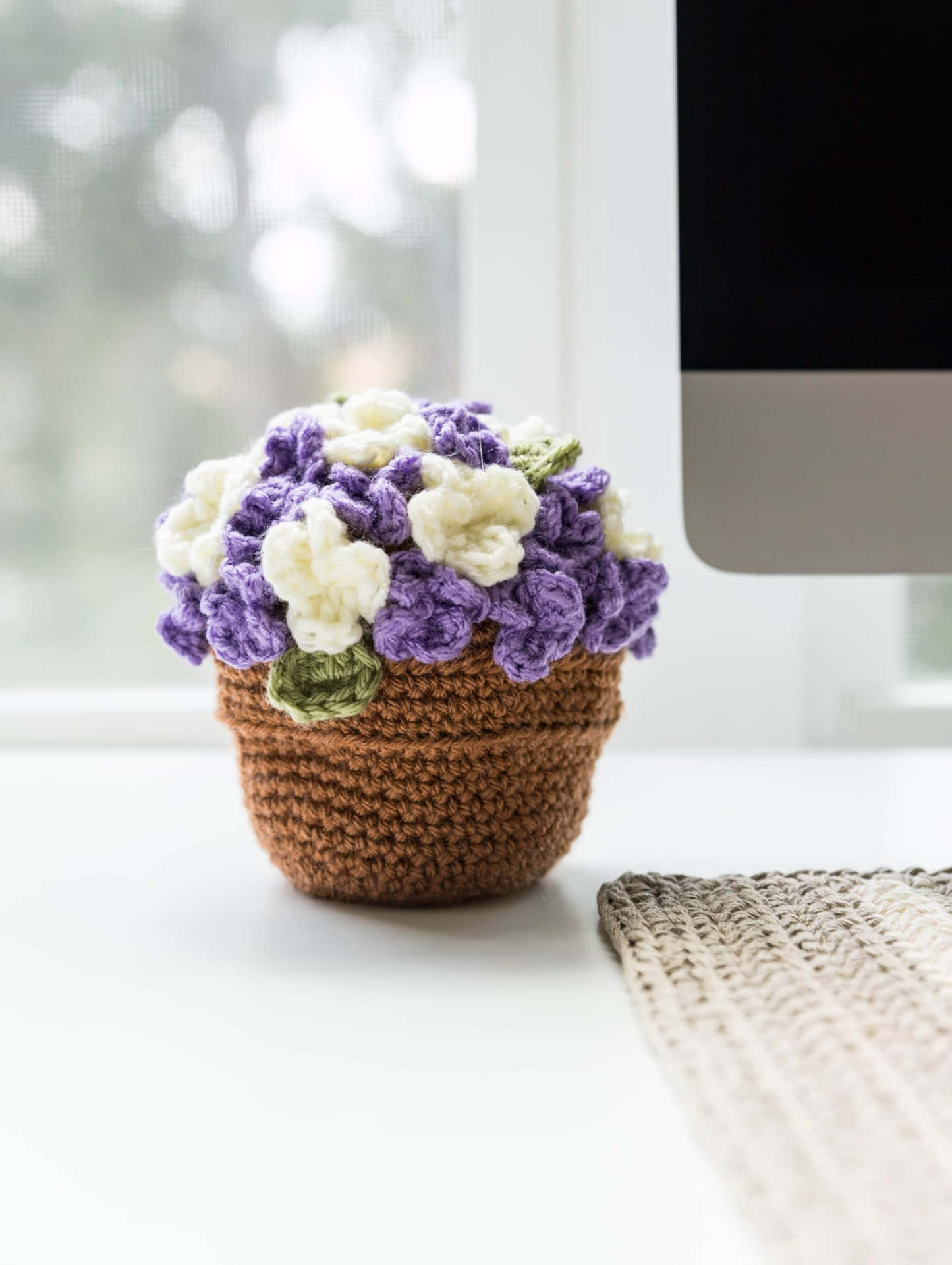 A Crocheted Flower Pot Sitting On A Desk