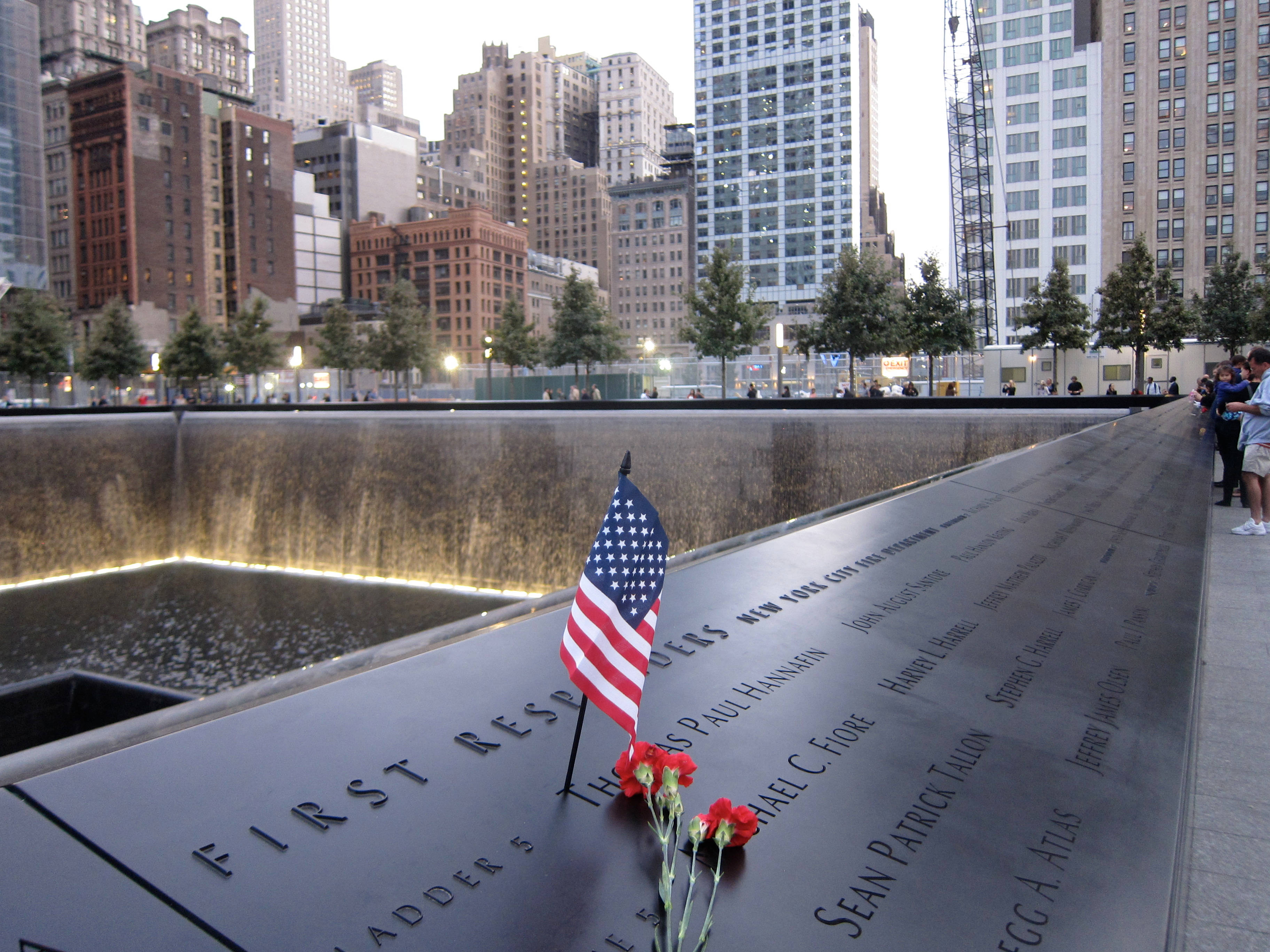 "A poignant tribute at the 911 Memorial - American flag and flowers" Wallpaper