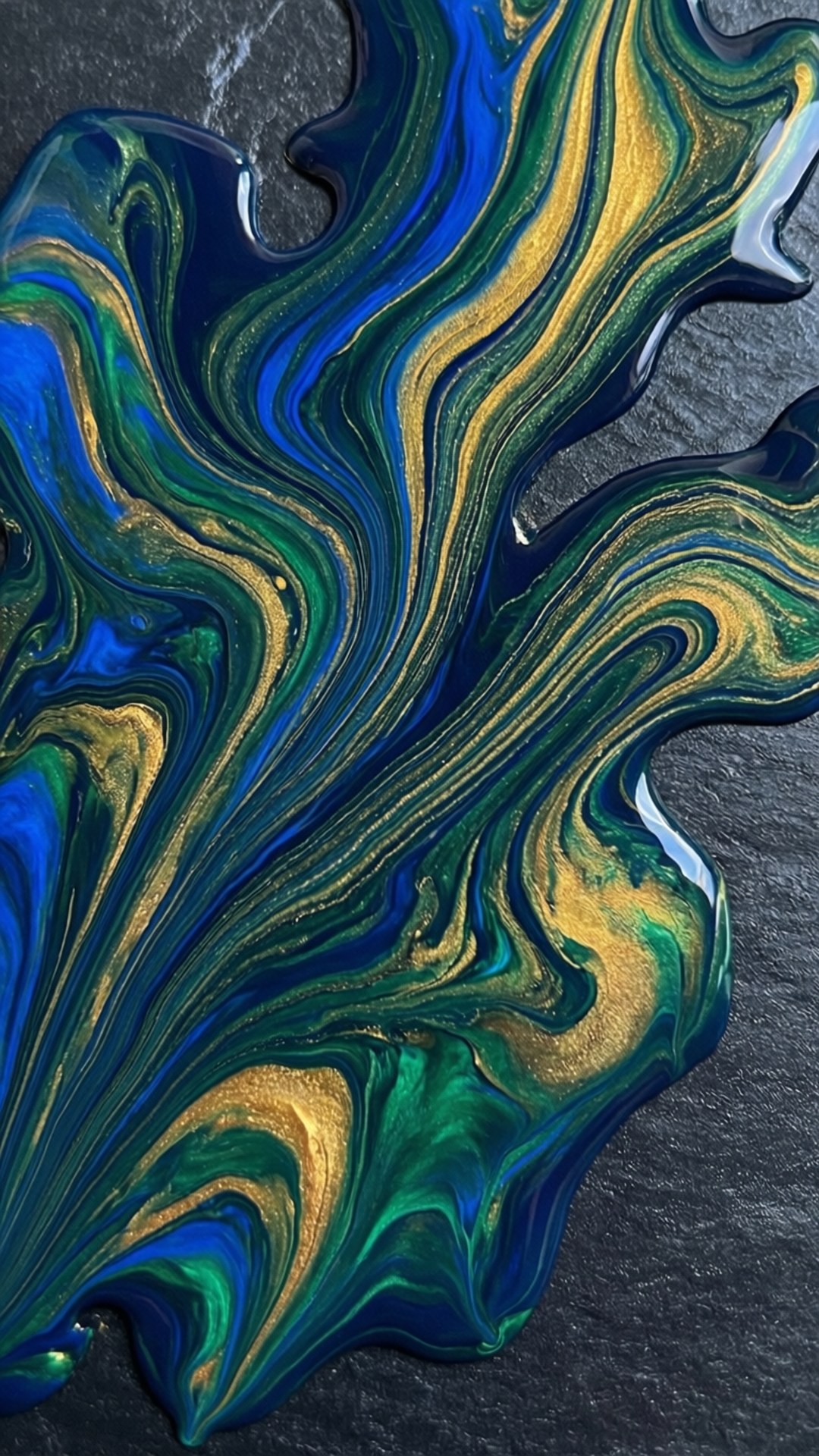 Fluid Slate Art Wallpaper — Vibrant swirling blues greens and golds of fluid paint flow across a dark textured surface.