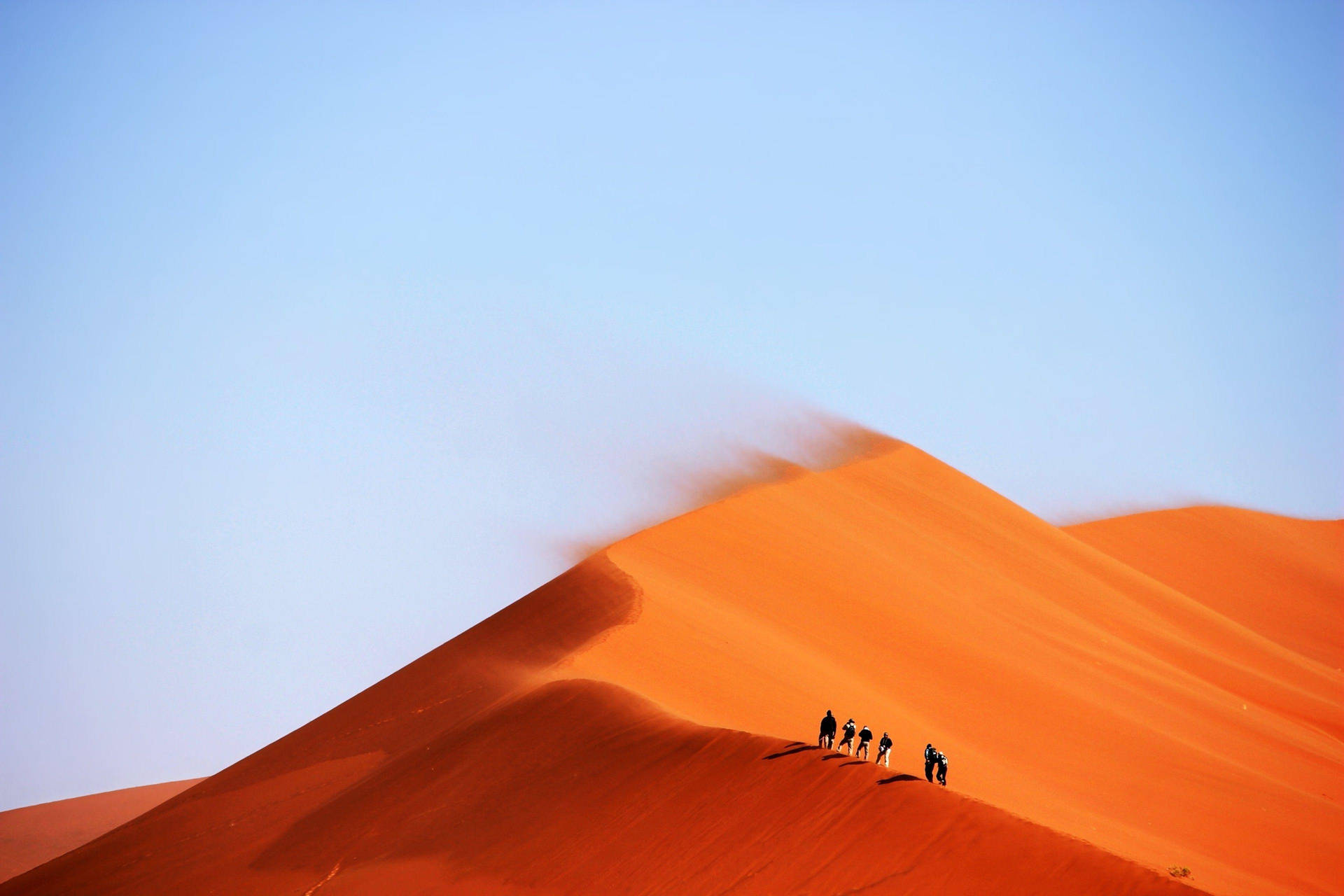 1)  A group of people seeking adventure, braving the elements in a windy desert! Wallpaper
