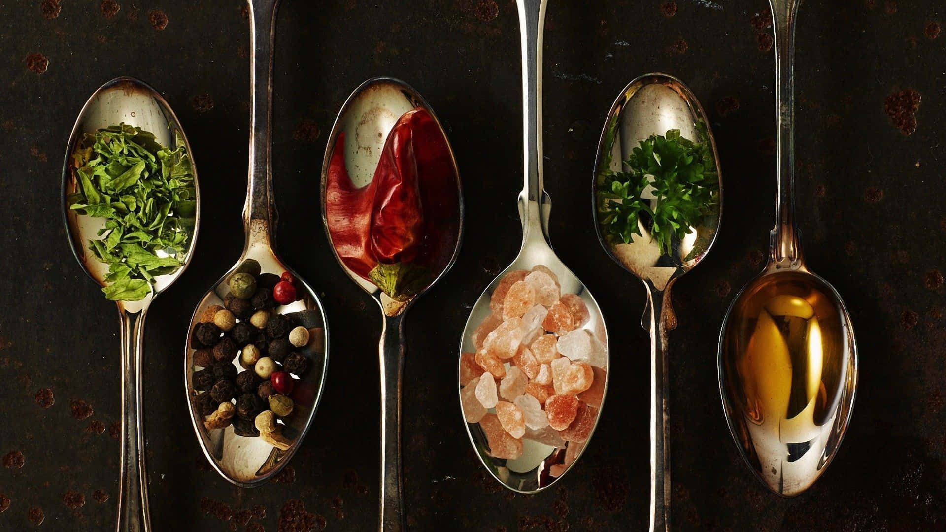 Classy Spoons With Various Food Spices Background