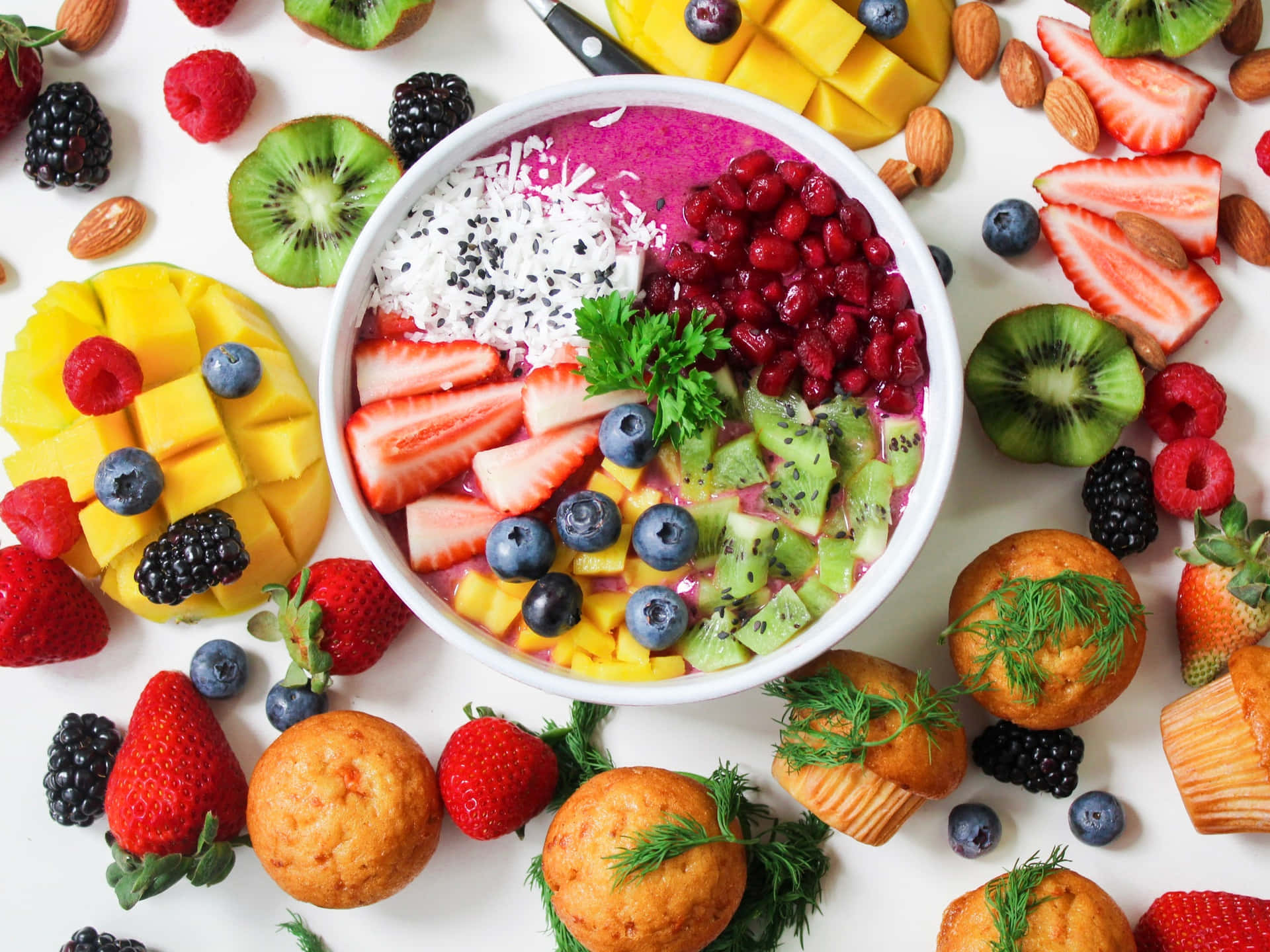 A Bowl Of Fruit And Muffins Surrounded By Fruit