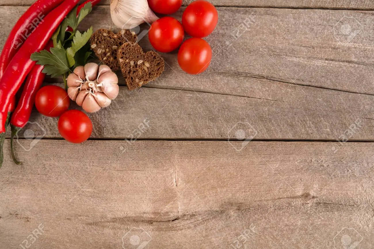 friske tomater, hvidløg, chilipeber og krydderier på en træ baggrund Wallpaper