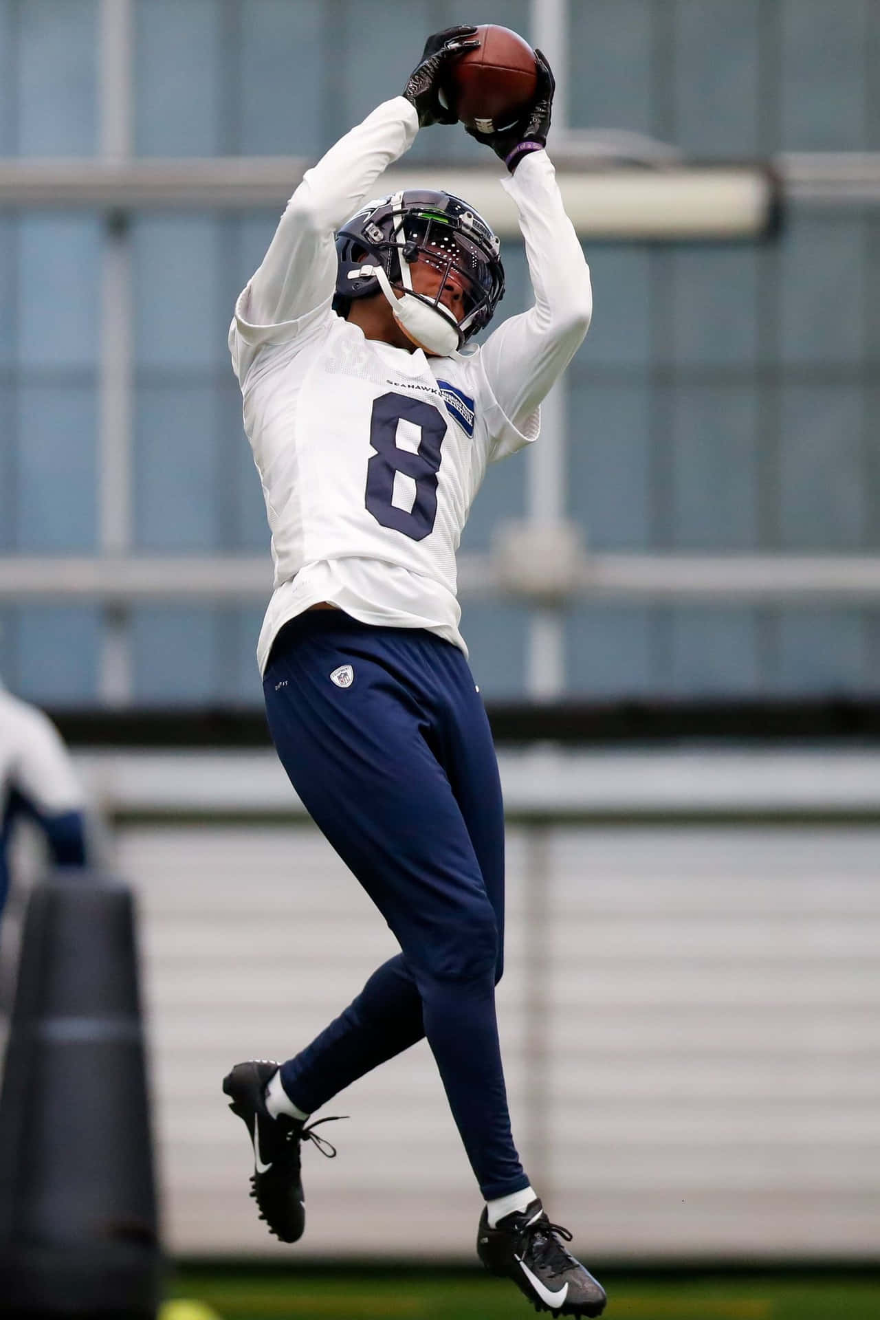 Football Player Catching Ball During Practice Wallpaper