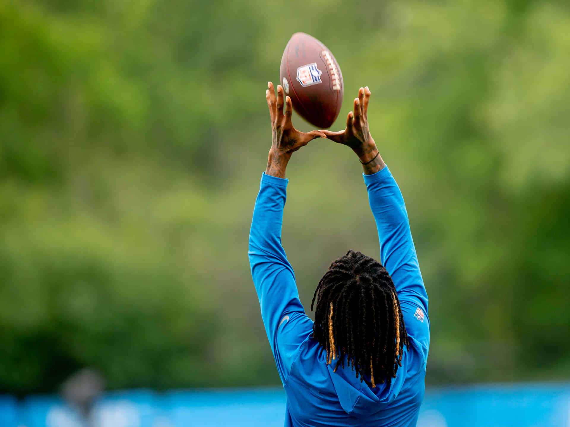 Football Player Catching Ball Practice Session Wallpaper