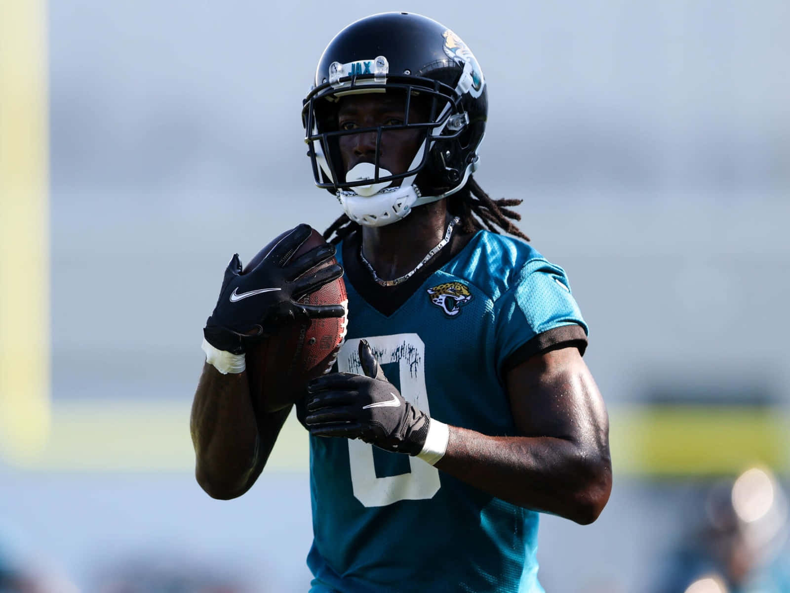 Football Player Holding Ball During Practice Wallpaper