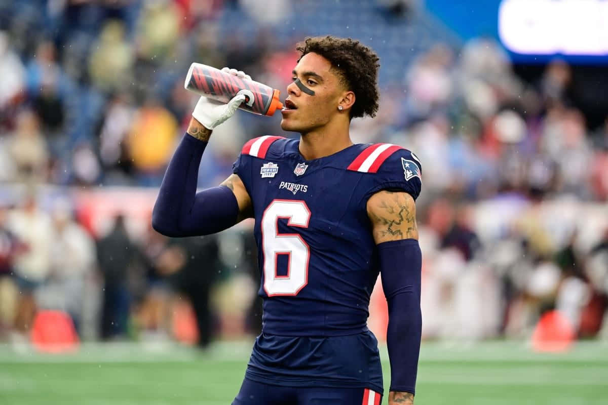 Football Player Hydration During Game.jpg Wallpaper
