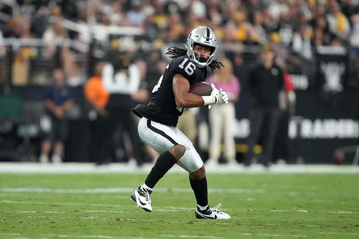 Football Player Running With Ball During Game Wallpaper