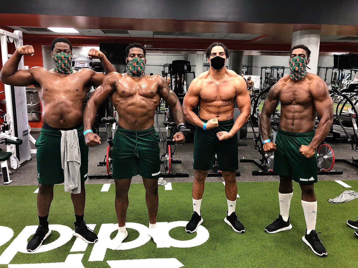 Football Players Showing Off Musclesin Gym Wallpaper