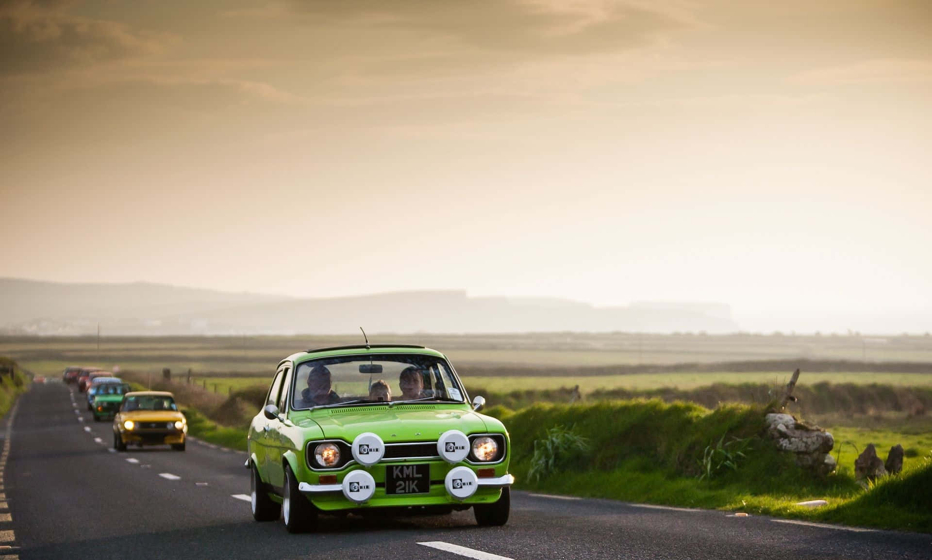 Vintage Ford Escort cruising down the highway Wallpaper