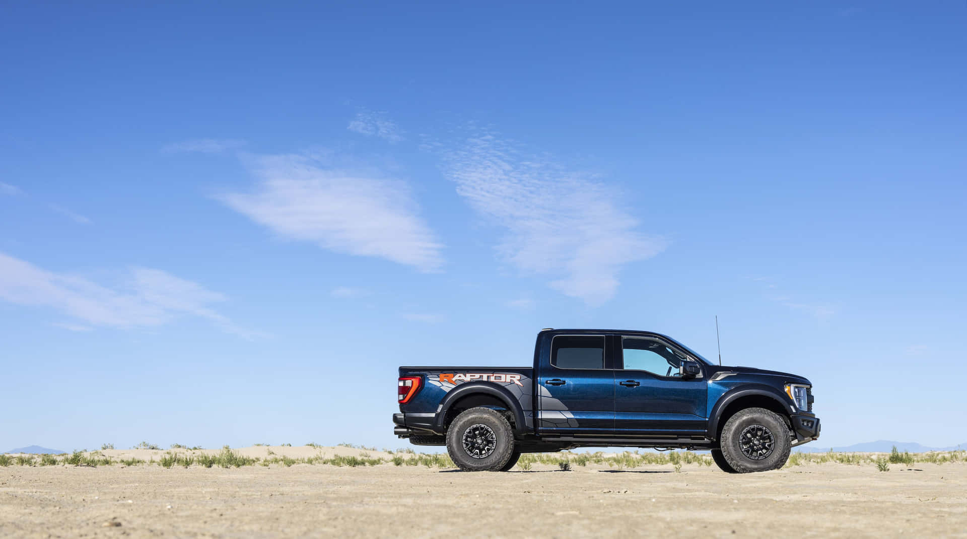 A Blue Truck Is Parked In The Desert Wallpaper