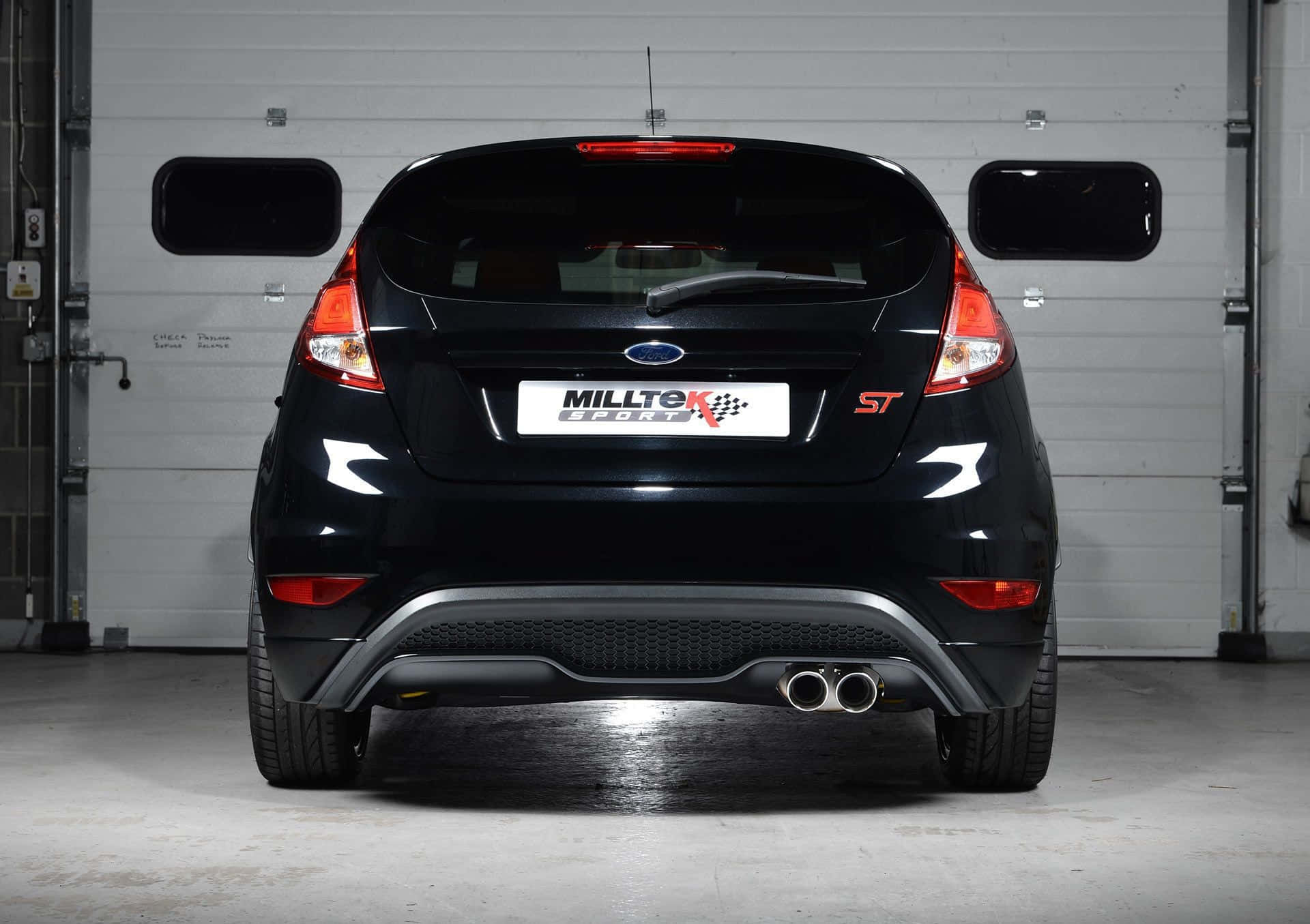 Sleek Red Ford Fiesta on a Picturesque Road Wallpaper