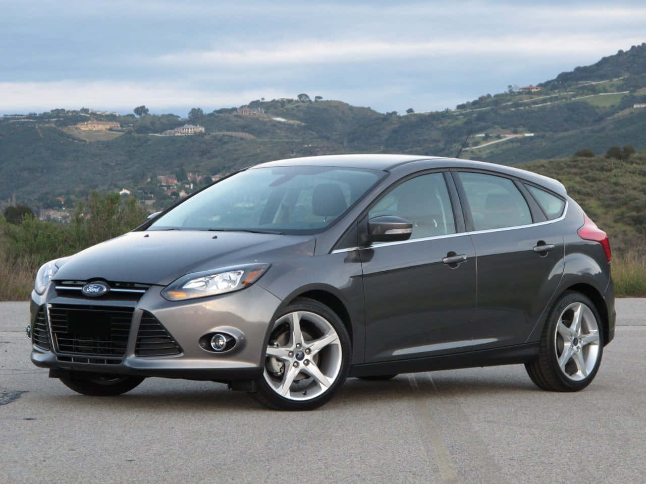 Sleek Ford Focus parked on a vibrant city street Wallpaper