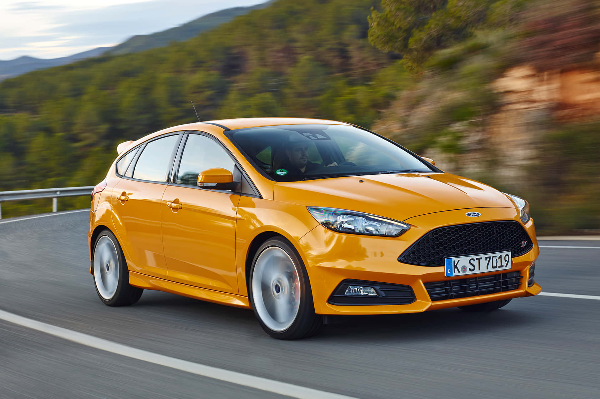 Sleek Ford Focus gliding on an open road under a beautiful sky Wallpaper