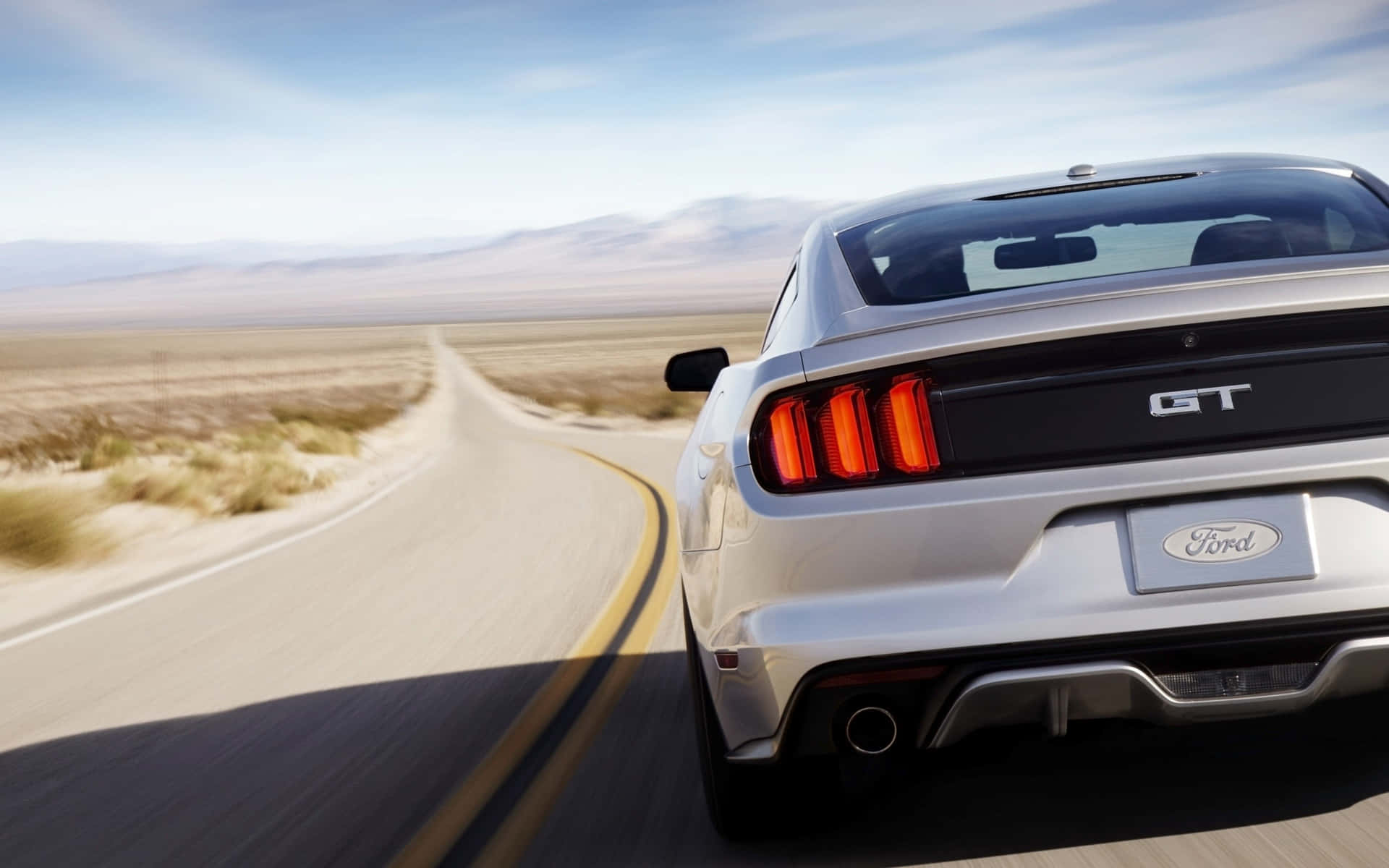 Caption: "2015 Ford Mustang GT Roaring Down the Highway" Wallpaper