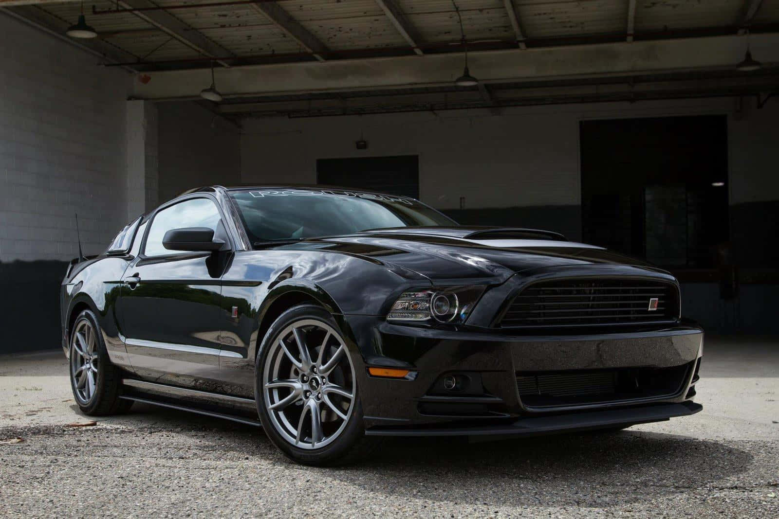 Sleek Ford Mustang Roush showcased under dramatic lighting Wallpaper