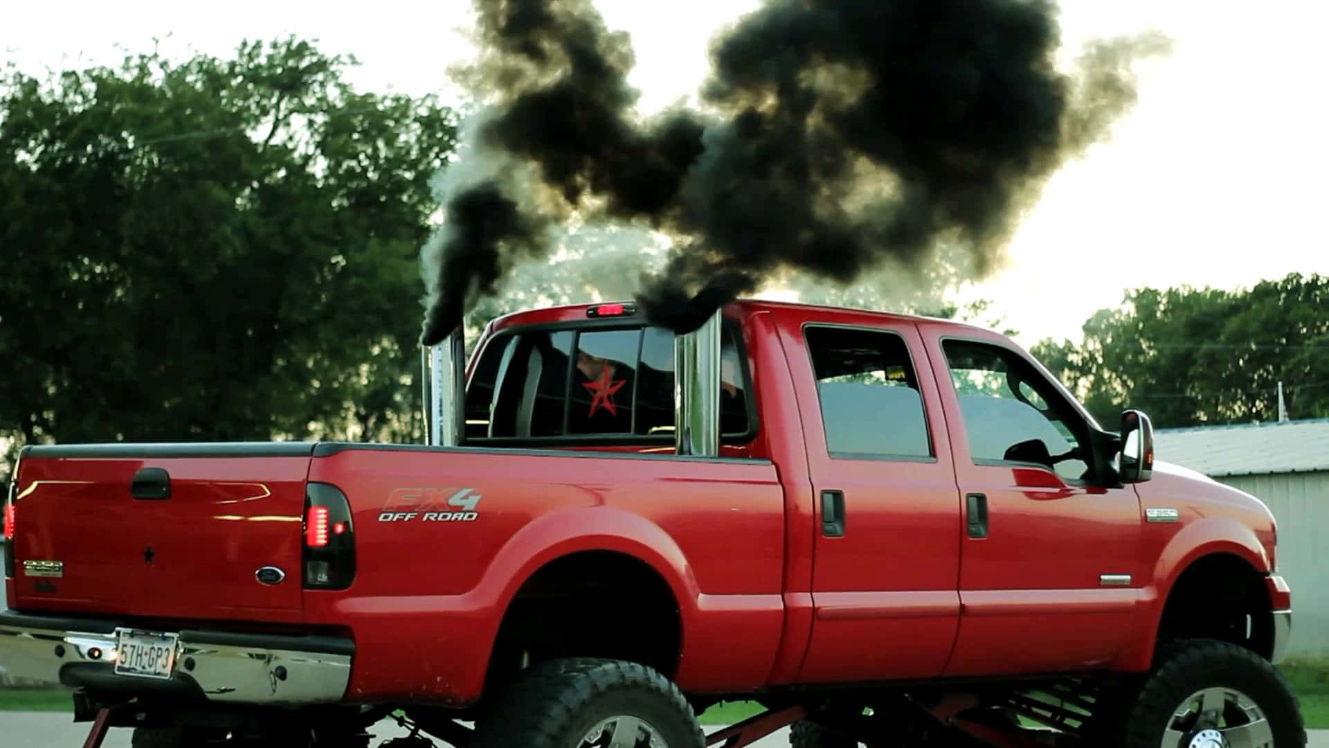 En rød lastbil med sort røg der kommer ud bagpå Wallpaper