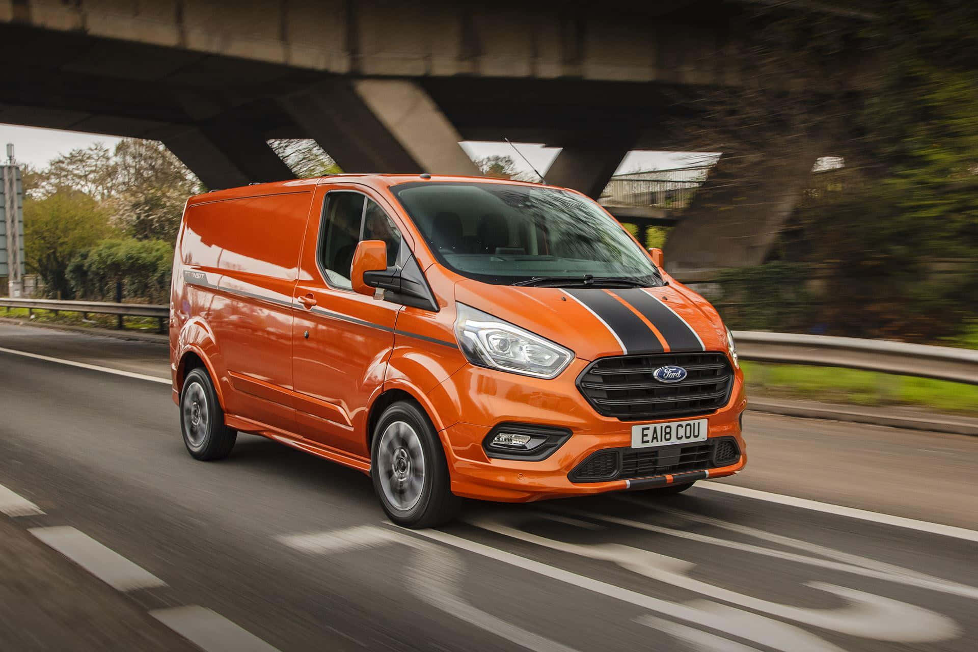 Sleek Ford Transit confidently cruising on a scenic road Wallpaper