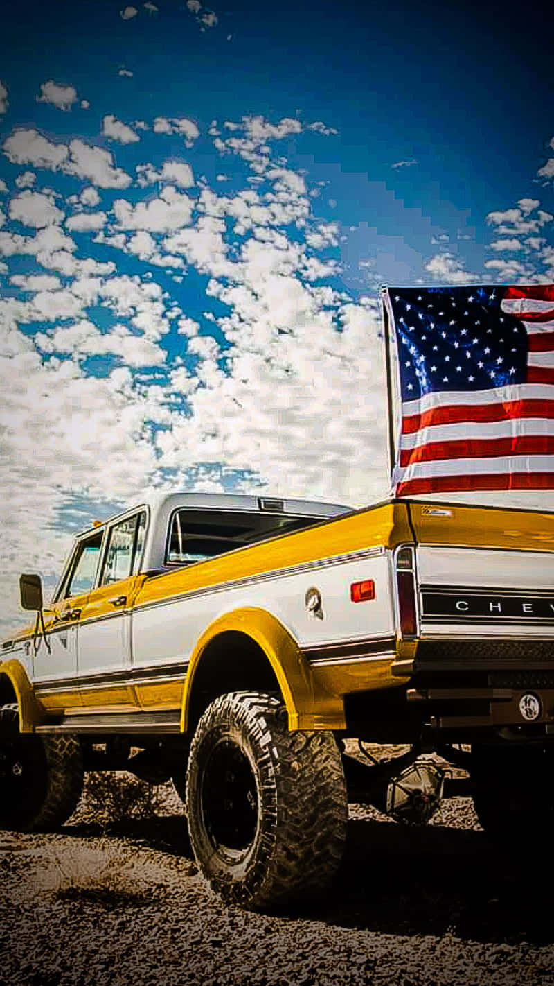 Uncamión Amarillo Con Una Bandera Americana Fondo de pantalla