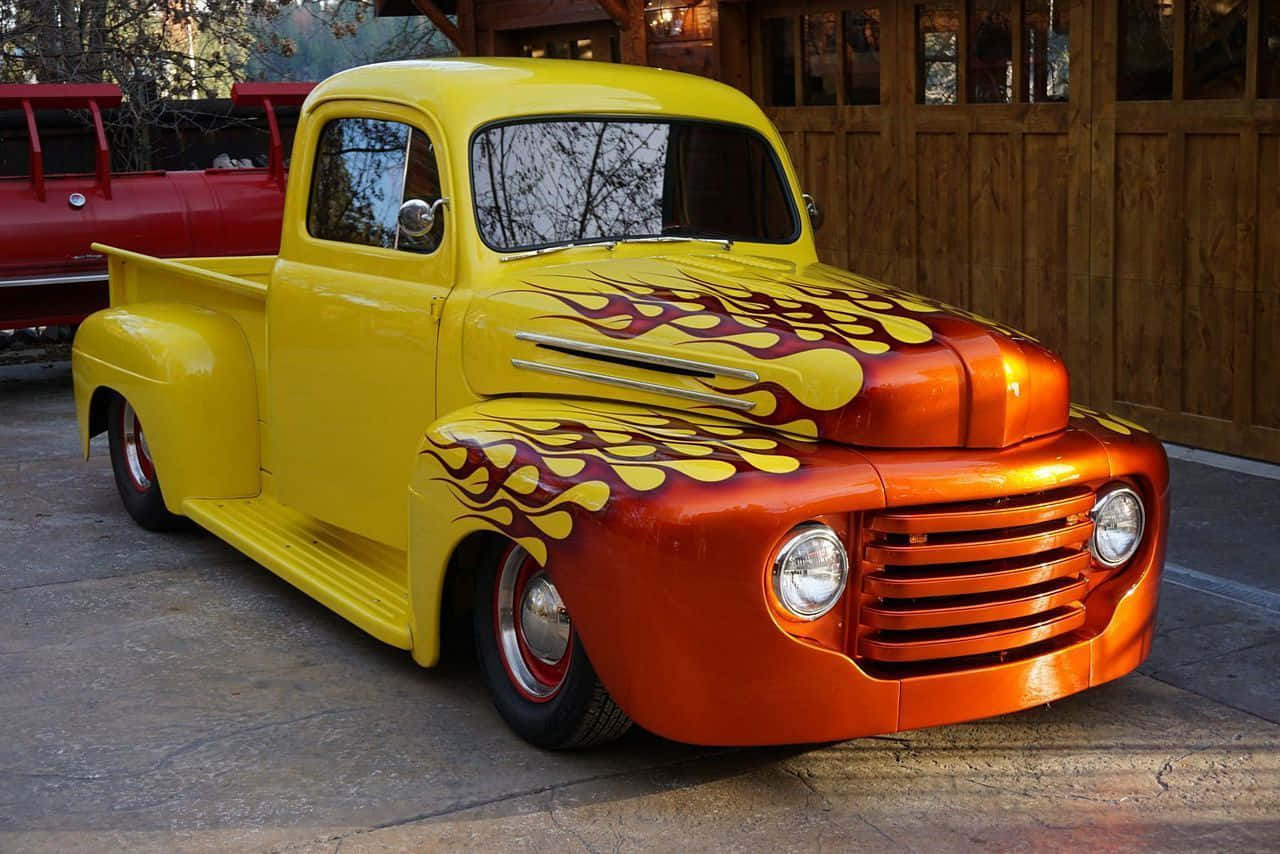A Yellow And Orange Truck With Flames Painted On It
