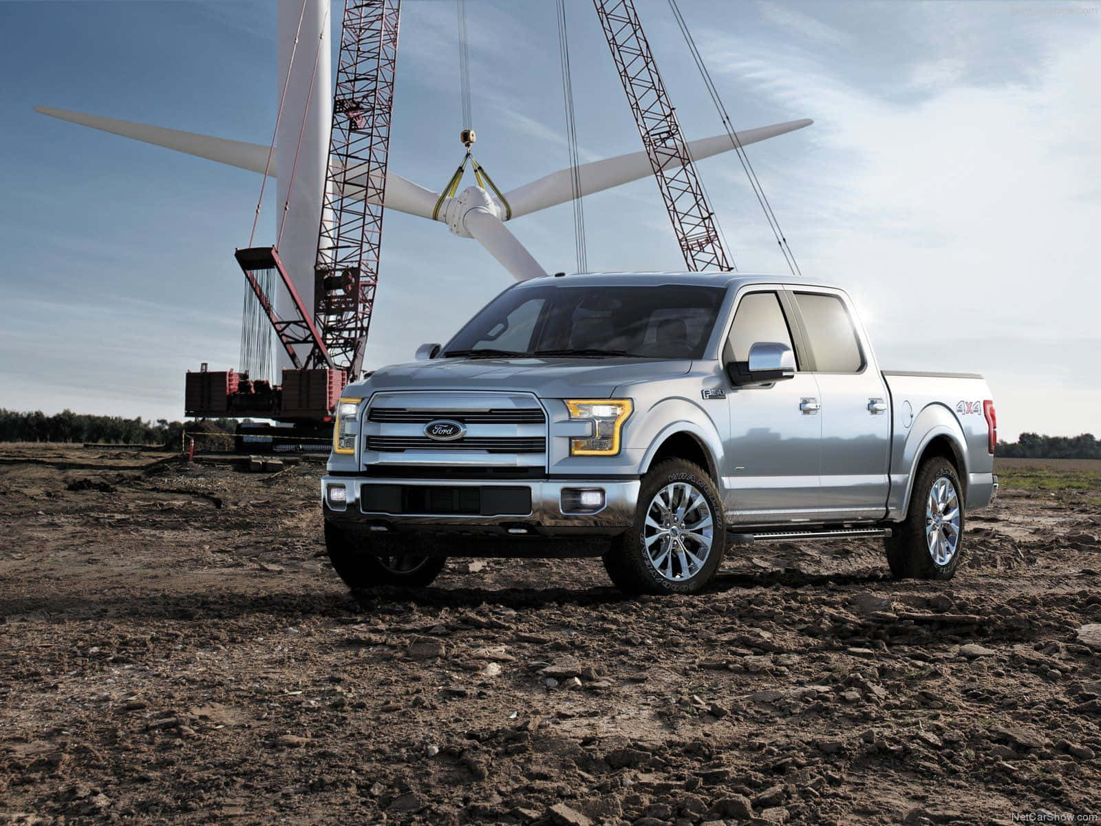 The Ford F - 150 Is Parked In Front Of A Wind Turbine